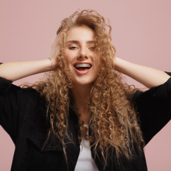 cheerful girl with curly hair holds her head
