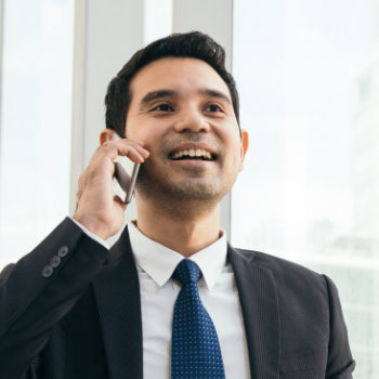 handsome amused businessman talking on the phone