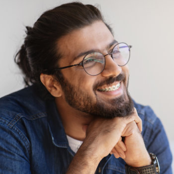 smiling indian man with eyeglasses and braces
